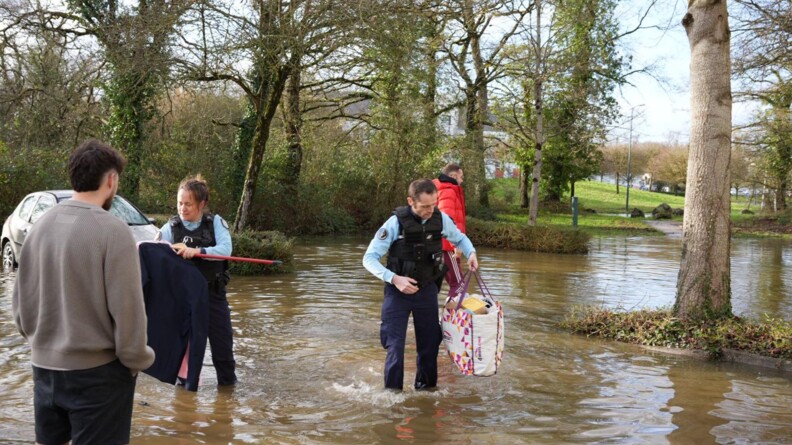 Gendarmes portant les affaires d'habitants sinistr&eacute;s par les inondations.