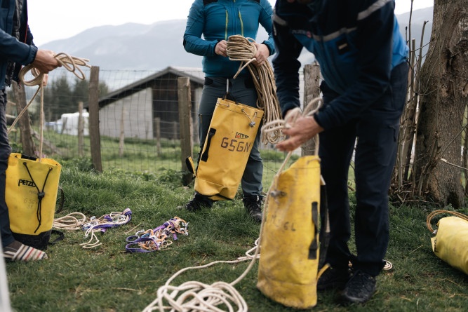 Agrandir l'image Photo montrant trois personnes en train de préparer des cordages et de les ranger dans des sacs étanches jaune marqués GSGN.