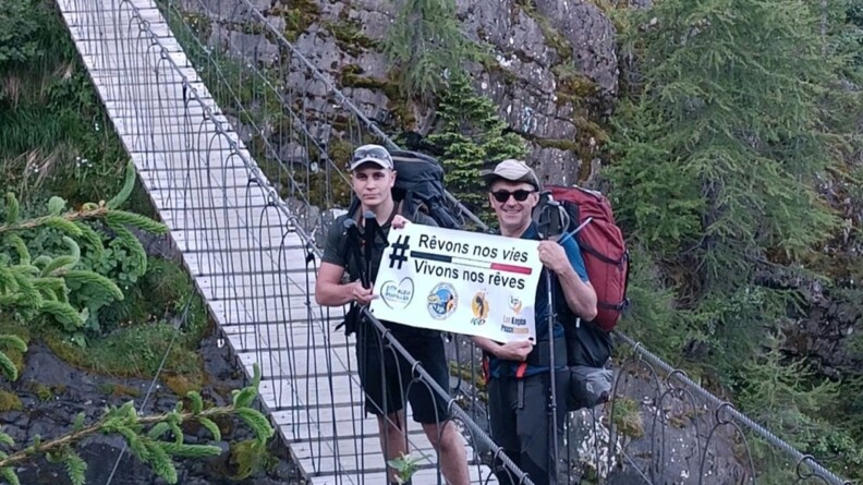 Tom et Bertrand sur un pont suspendu arborant la banderole des K&eacute;pis Pescalunes.