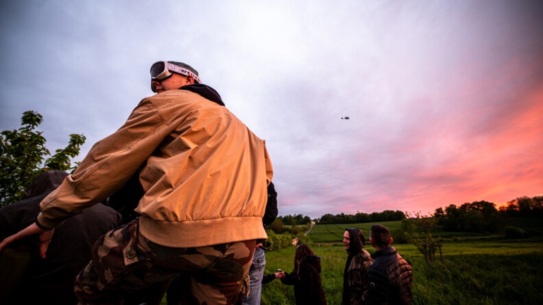 Un raver regarde l'hélicoptère de la gendarmerie avec un magnifique coucher de soleil