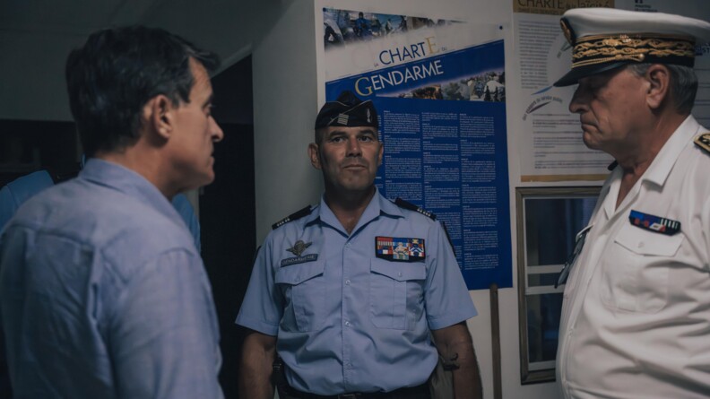 Au milieu de l'image se trouve un gendarme, un colonel en tenue d'&eacute;tat major. A sa gauche, se trouve le ministre des Outre-mer, Manuel Valls et &agrave; sa droite le pr&eacute;fet de l'ile.