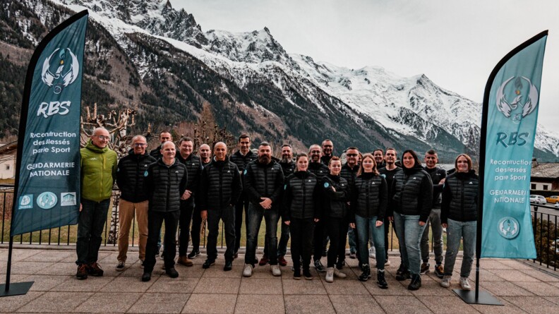 Photo de groupe des stagiaires et des encadrants du stage "esprit de cordée", avec, en fond, la montagne enneigée.