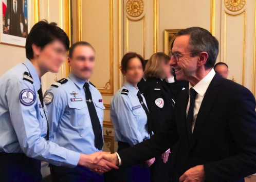Le ministre de l'Intérieur félicitant une officier de gendarmerie.