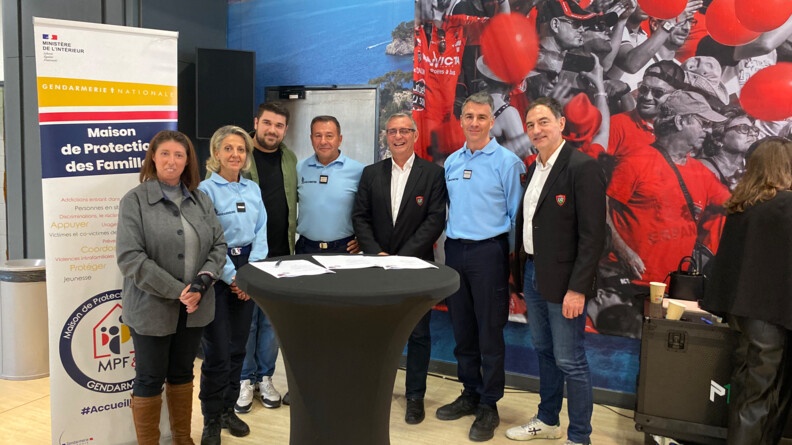 Trois gendarmes et plusieurs membres du Rugby club toulonnais posent, souriants, derri&egrave;re une table ronde, sur laquelle est pos&eacute;e la convention de partenariat sign&eacute;e entre les parties pr&eacute;sentes.