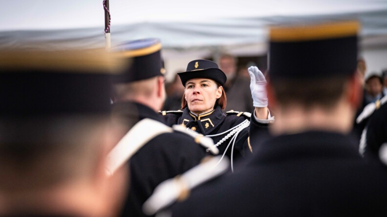 Les musiciens de la gendarmerie mobile de dos et en flou avec en fond et net la cheffe d'orchestre.