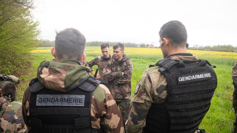 Agrandir l'image Des officiers-élèves au premier plan interceptent des miliciens à la lisière de la forêt