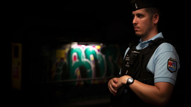 Réserviste devant un tag dans une station de métro.
