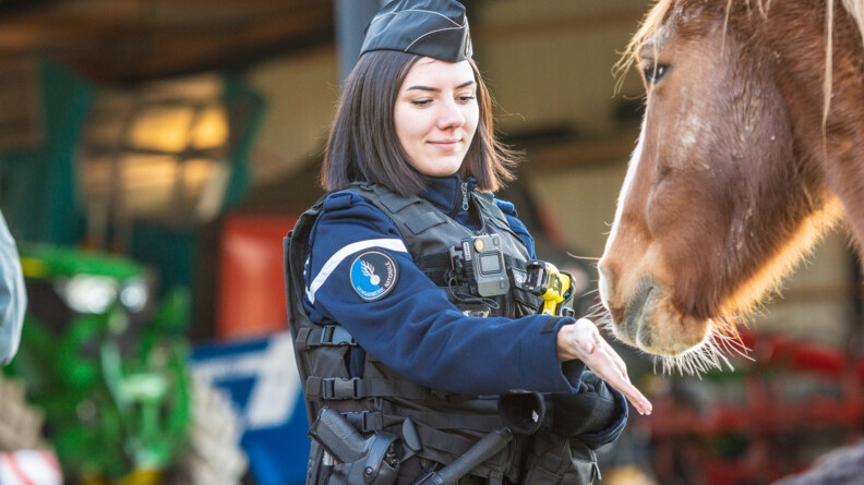 Une gendarme de la COB de Guerlédan, dans les Côtes d'Armor, avec un cheval dans un centre équestre.