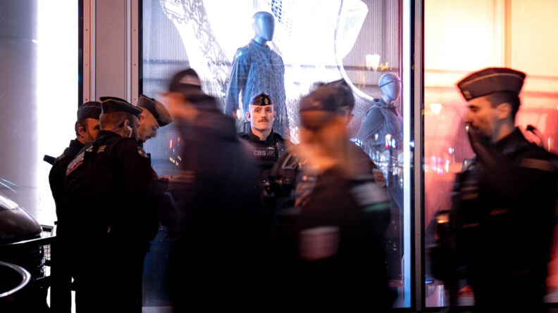 Des gendarmes mobiles devant une vitrine de magasin