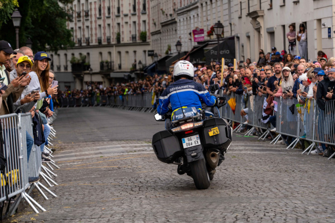 Agrandir l'image Un motocycliste de la gendarmerie roule dans les rues de Paris, lors de la dernière étape du tour de France 2025