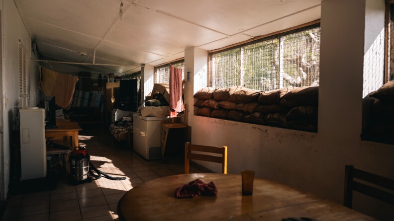 vue de l'int&eacute;rieur d'une pi&egrave;ce aux feni&ecirc;tres grillag&eacute;es dont les bords sont surmont&eacute;s de sacs de sable