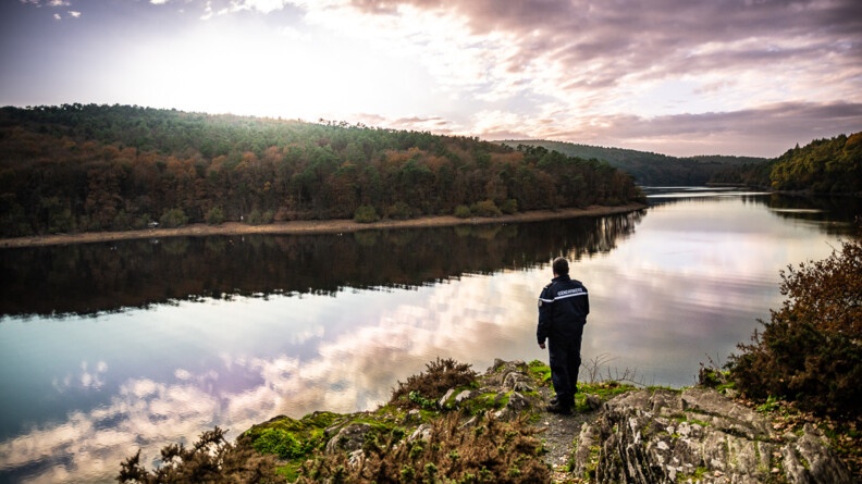 Un gendarme de la COB de Guerlédan, dans les Côtes d'Armor, avec son véhicule, au lac de Guerlédan.