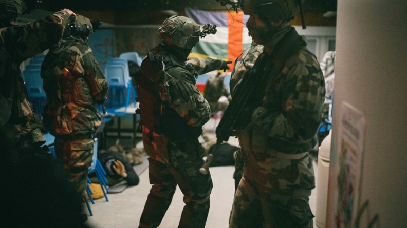 LEs militaires entrent dans une pièce avec des rebelles