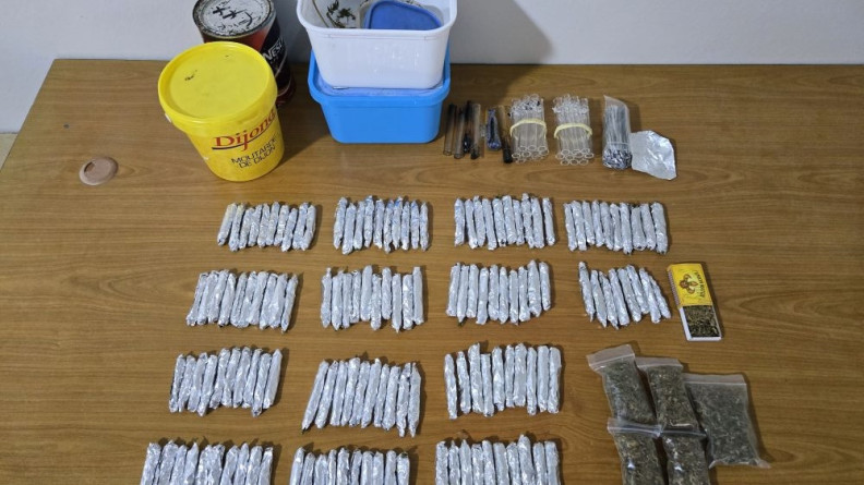 Agrandir l'image Photo d'une saisie de plusieurs grammes de canabis et de matériel servant à la consommation de celui ci. Tout cela est posé sur une table en bois