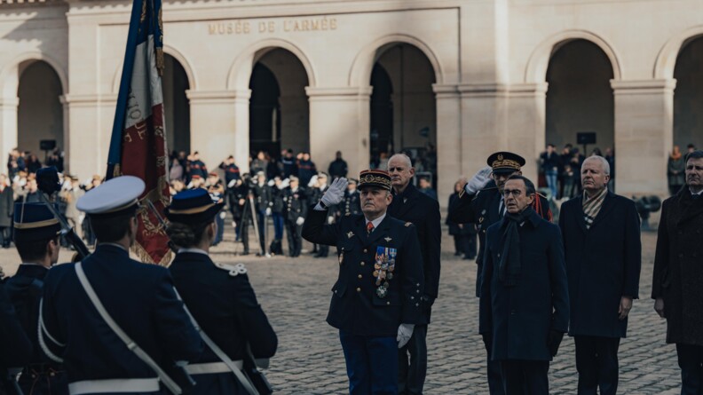 Le directeur général de la gendarmerie nationale et le ministre de l'intérieur devant le drapeau de la gendarmerie au cour d'une cérémonie de gendarmerie dans la cour pavée des invalides