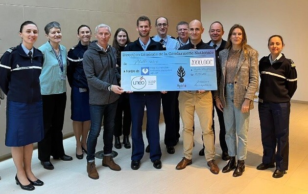 Dans l'angle d'une salle aux murs et sol clairs,un groupe de 15 personnes composés de gendarmes et de civils posent autour du chèque de 1000 euros remis à l'hôpital Necker suite à la participation des gendarmes à l'EcoTrail de Paris 2023