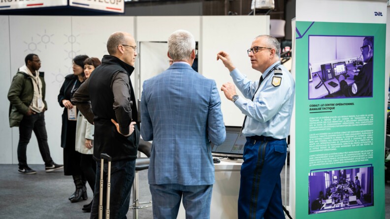 Un gendarme explique son atsnd &agrave; deux hommes en civil &agrave; Milipol