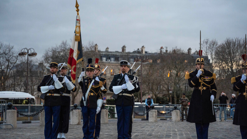 Sur le parvis de l'Arc de Triomphe, la garde au drapeau compos&eacute;e de six gendarmes en grande tenue. A ses c&ocirc;t&eacute;s, un garde r&eacute;publicain au garde &agrave; vous, sabre en main.