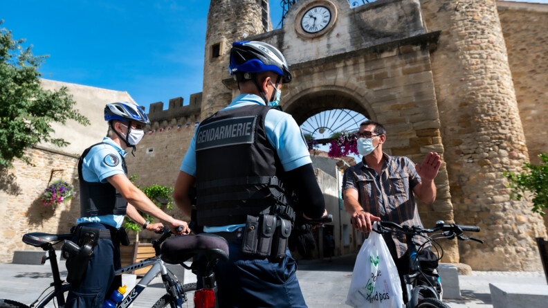 Devant le Ravelin, l’ancienne porte des remparts de Camaret-sur-Aigues, les gendarmes échangent avec un habitant.