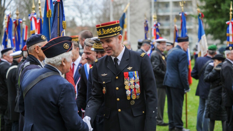 Le général commandant la région Nouvelle Aquitaine, suivi du préfet et d'autres autorités civiles, serre la main à un porte-drapeau vu de dos, à côté duquel sont alignés une douzaine d'autres porte-drapeaux que les autorités saluent.