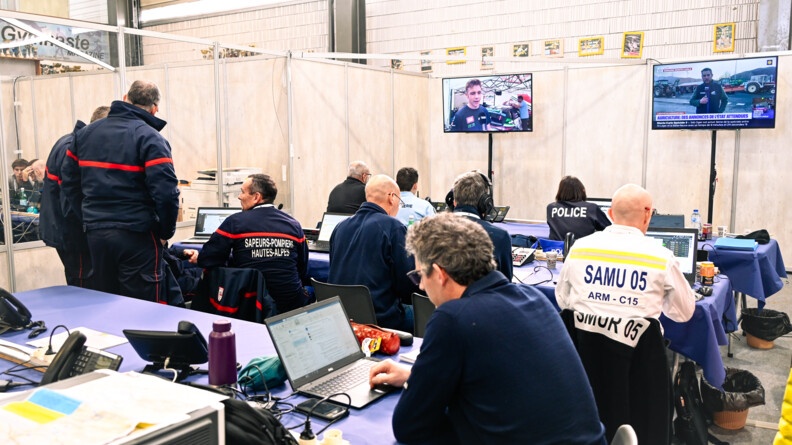Dans une salle, des pompiers, des gendarmes, des personnels de la préfecture et d'autres acteurs de l'état, travaillent à la sécurisation de l'événement.