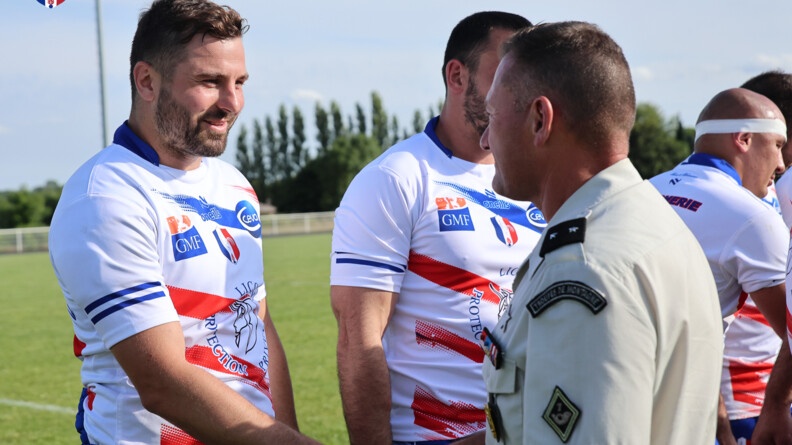 Agrandir l'image Un général de brigade (à droite) serre la main d'un joueur du XV gendarmerie (à gauche) pour le féliciter