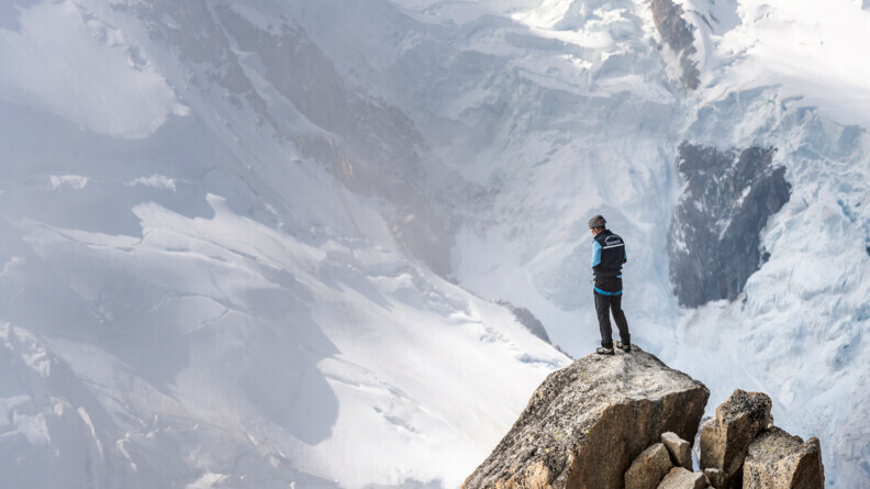 Agrandir l'image Un gendarme sur le haut d'un rocher devant la montagne.