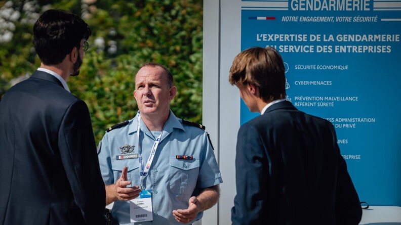 Gendarme échangeant avec des participants de la 6e édition de la Rencontre des entrepreneurs de France (REF) à l’hippodrome Paris-Longchamp.