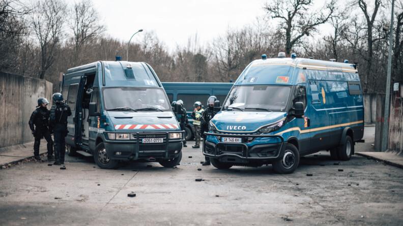 Vue de face d'un Irisbus et d'un véhicule de maintien de l'ordre à St Astier