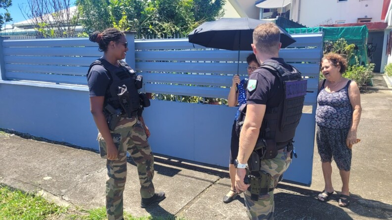 Des gendarmes discutent avec des habitants devant leur maison, apr&egrave;s le passage du cyclone Garance sur l'&icirc;le de la R&eacute;union.