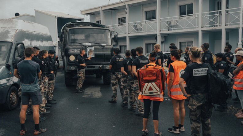 des gendarmes er pesonnels d ela croix rouge alignés devant un camion pour préparer une mission