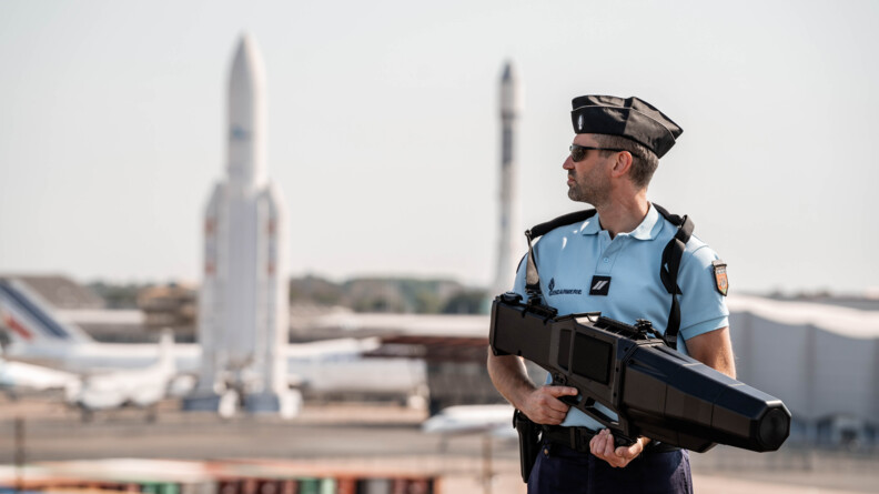 Agrandir l'image Gendarme avec fusil de brouillage positionné sur le toit du village média.