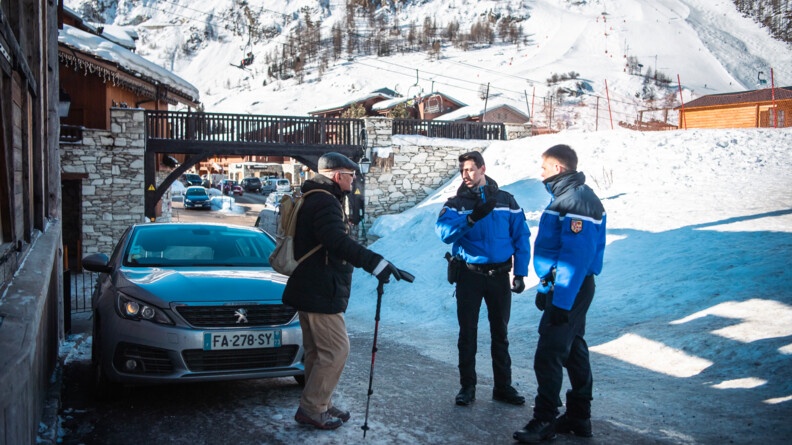 Deux gendarmes échangent avec un homme d'un certain âge.