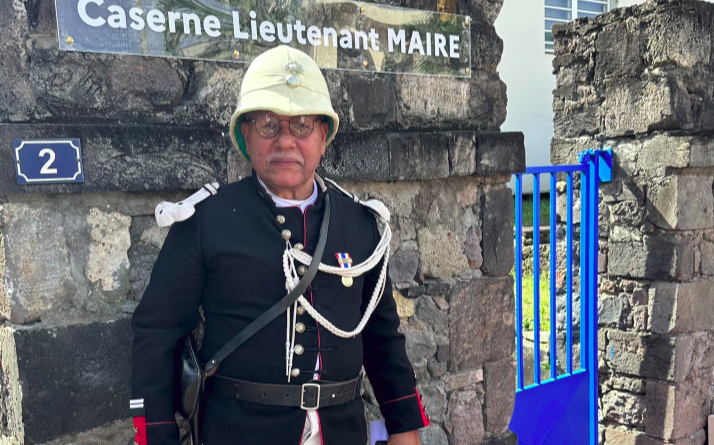 Un acteur en costume d'époque devant la plaque commémorative "caserne lieutenant maire"