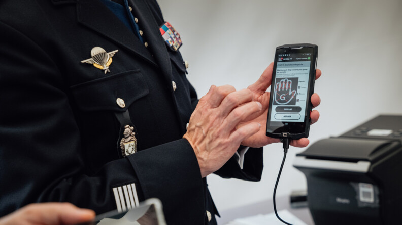 La main d'un colonel tenant un t&eacute;l&eacute;phone pr&eacute;sentant l'innovation.