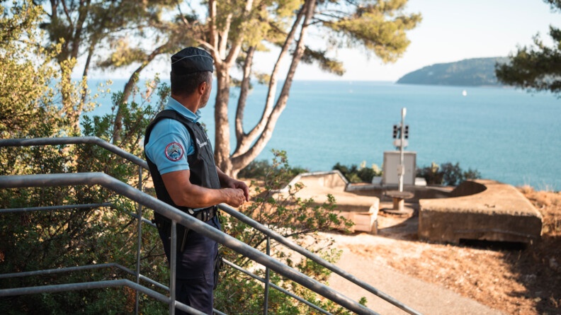 Sous un grand ciel bleu en extérieur, un militaire de la GARM regarde un radar qui donne sur la passe de Toulon