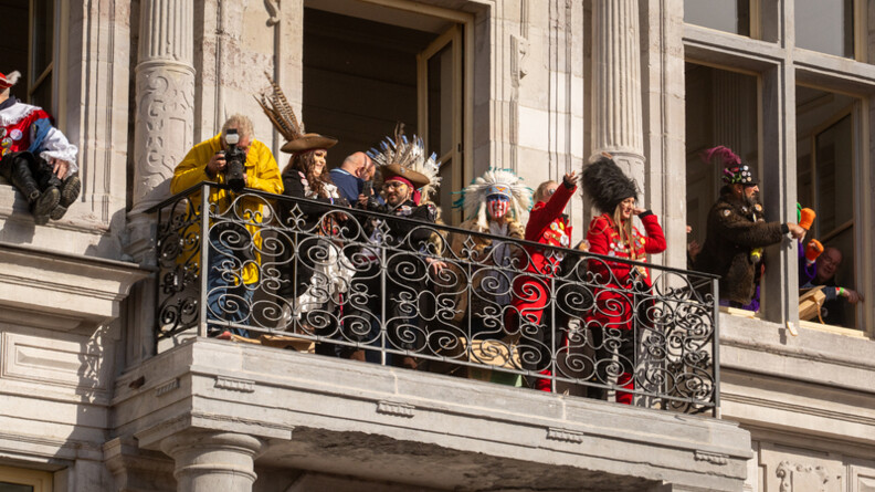 Photo de carnavaleux d&eacute;guis&eacute;s au balcon de l'H&ocirc;tel de ville de Bergues. la m&eacute;t&eacute;o est ensoleill&eacute;e.