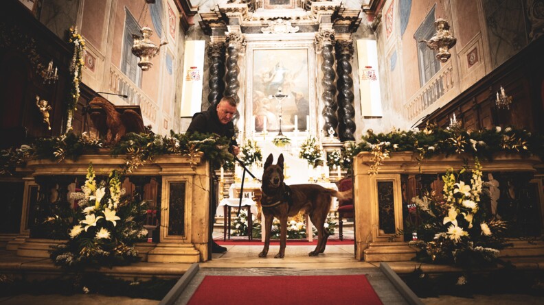 Chien spécialisé en explosifs avec son maître dans une église.