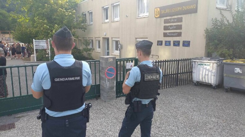 Agrandir l'image Deux gendarmes devant l'entrée d'un collège.