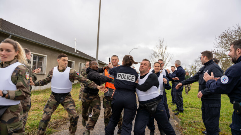 Gendarmes et policiers protègent le porteur d'une flamme olympique fictive lors d'une simulation d'attaque.