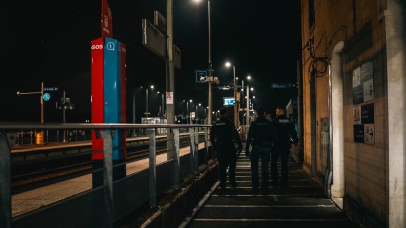 Trois gendarmes patrouillent dans une gare. Il fait nuit et sombre.
