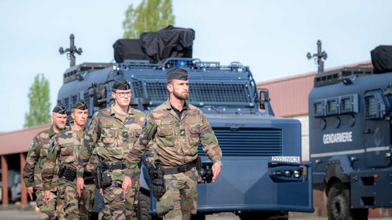 4 gendarmes composant un équipage du Centaure marchent au pas pour rejoindre les rangs après leur descente des Centaure, derrière l'ensemble des troupes