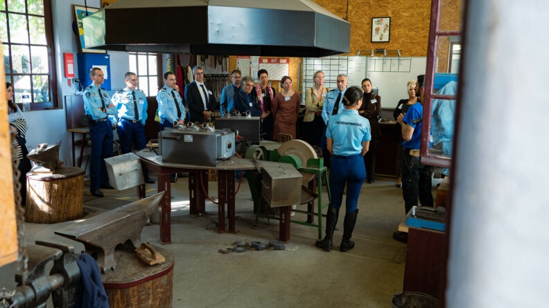 Agrandir l'image Les parrains et filleuls du mentorat cyber visitent l'atelier de maréchalerie de la Garde république au milieu duquel trône la forge.