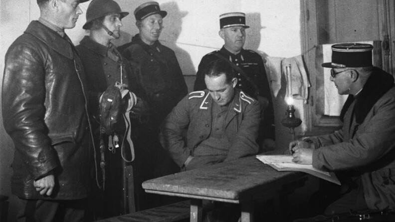Des gendarmes interrogent un prisonnier allemand.