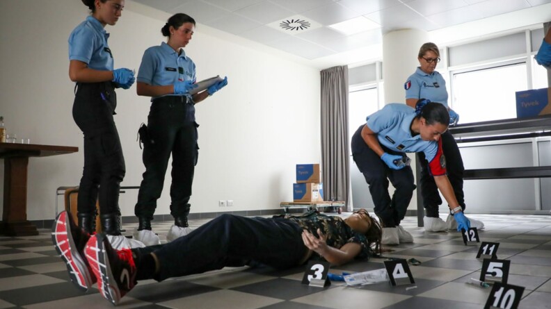 Dans une salle, un manequin est posé au sol, c'est la victime. Les élèves s'entrainent et relèvent les preuves.