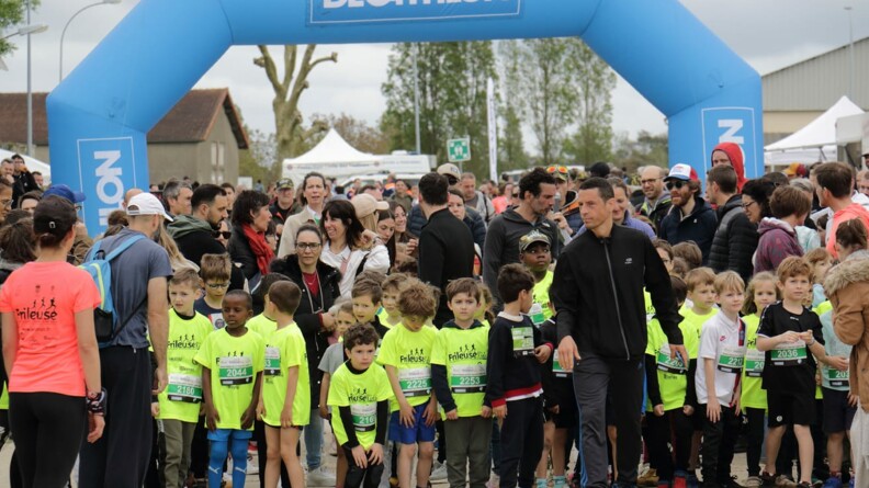 Agrandir l'image Sous une arche décathlon bleu ciel, une vingtaine d'enfants portant un t-shirt jaune fluo "la frileuse" s'apprêtent à prendre le départ, entourés par leurs parents
