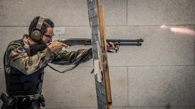Militaire s'entrainant au fusil à pompe dans le stand de tir.