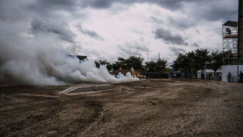 Nuages de lacrymogène et un peloto de gendarmes mobiles au fond du terrain