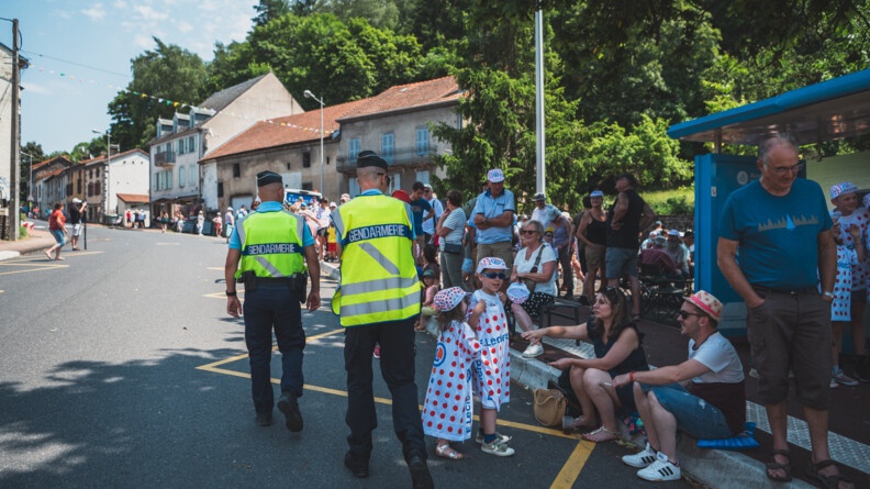 Deux gendarmes échangent avec les gens venus nombreux assister aux passages de la caravane et des courreurs.