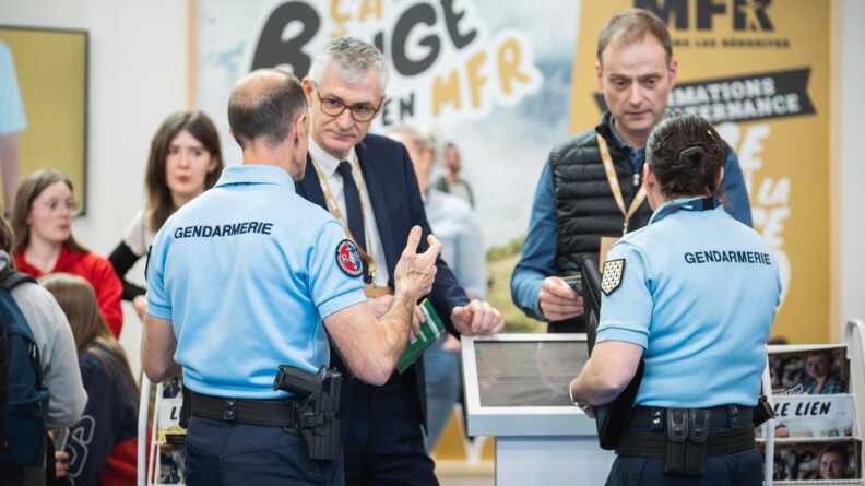 Deux gendarmes de dos sont entrain de parler avec deux agriculteurs.